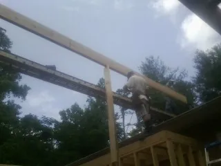 Carpenter setting a ridge beam over a new addition frame — Ice Dam Removal by Roofing Brothers in Beverly Shores