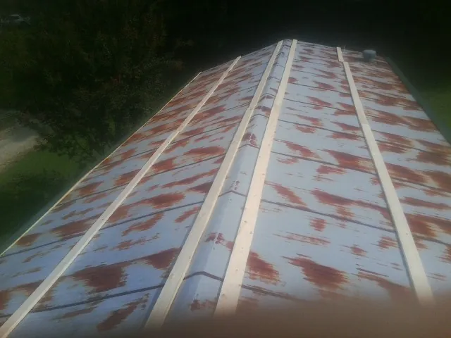 Rusted metal roof panels with new wood purlins before replacement — Storm Damage Roof Repair in Beverly Shores by Roofing Brothers