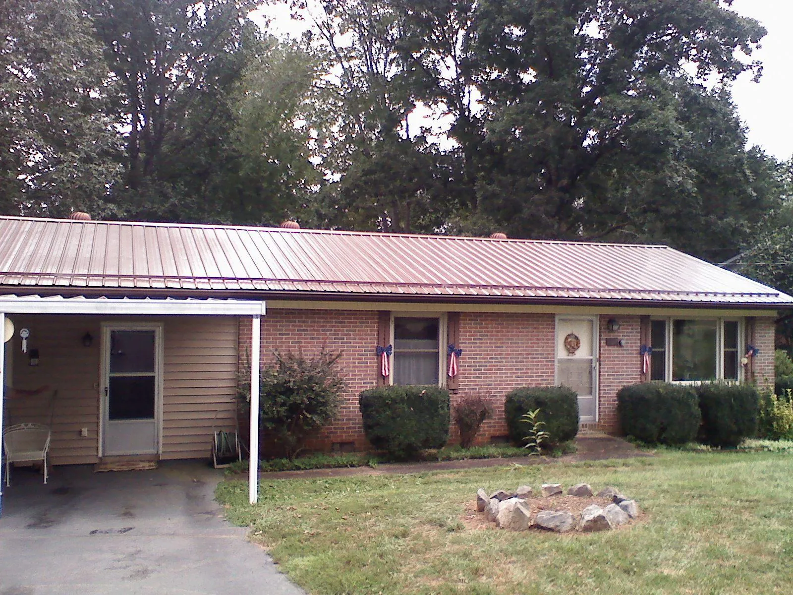 Bronze metal roof and carport on a brick ranch home — Roof Repair work by our crew in Beverly Shores